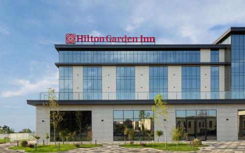 un bâtiment avec une enseigne d'auberge de jardin hilton en haut dans l'établissement Hilton Garden Inn Samarkand, à Samarcande