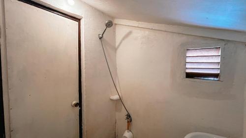 ein Badezimmer mit Toilette und Fenster in der Unterkunft Islo Hut Kanan in General Luna