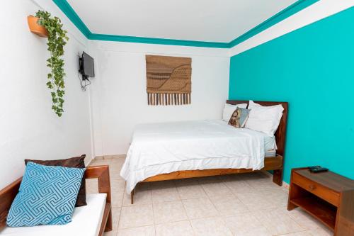 1 dormitorio con 1 cama con techo azul en LUTIX HOTELS, en El Limón