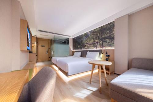 深圳的住宿－深圳南山南新路秋果，一间卧室配有两张床、一张桌子和一张沙发
