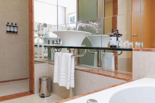 y baño con lavabo y espejo. en Doubletree By Hilton Buenos Aires en Buenos Aires