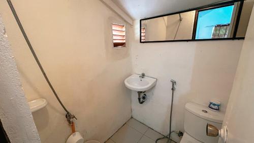 a small bathroom with a toilet and a sink at Islo Hut Kaliwa in General Luna