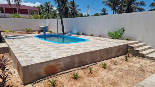 una piscina en un patio junto a una pared en Oasis De Areia Casa a Beira Mar na Praia de Zumb, en Rio do Fogo