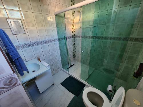 uma casa de banho com um chuveiro, um WC e um lavatório. em CaliForte House em Cabo Frio