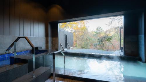 a swimming pool with a large window in a house at OND HOTEL（オンドホテル） in Takeo