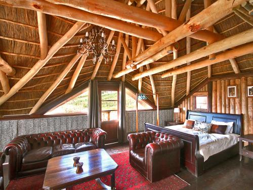 ein Wohnzimmer mit einem Bett und Ledermöbeln in der Unterkunft Chamonix in Franschhoek