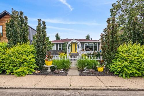 a house with a yellow door and a white fence at YEG Chic Luxury Accommodation in Edmonton