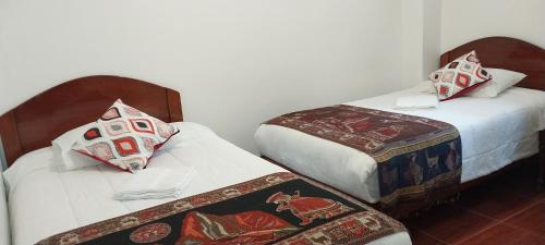 two beds in a small room withskirts at Catari's House in Machu Picchu