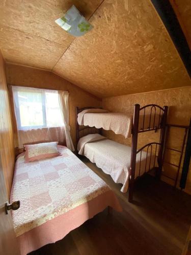 a small room with two bunk beds in it at Cabaña vista hermosa in Neltume