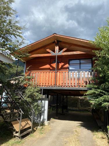 a large wooden cabin with a large deck at Cabaña vista hermosa in Neltume