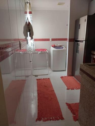 Il comprend une cuisine dotée de sols rouges et blancs et d'un réfrigérateur. dans l'établissement Apartamento Rio das Ostras, à Rio das Ostras