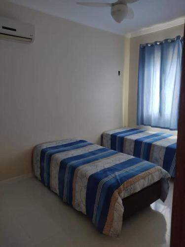 - une chambre avec 2 lits et une fenêtre dans l'établissement Apartamento Rio das Ostras, à Rio das Ostras