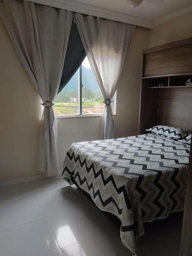 sypialnia z dużym łóżkiem i oknem w obiekcie Apartamento Rio das Ostras w mieście Rio das Ostras