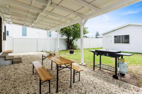 a patio with a ping pong table and a ping pongopter at Easts Beach Escape - A Relaxed Coastal Cottage in Wollongong