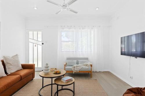 a living room with a couch and a table at Easts Beach Escape - A Relaxed Coastal Cottage in Wollongong