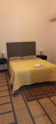 a bedroom with a bed with a yellow bedspread at Hostal Adelita in Moisés Ville