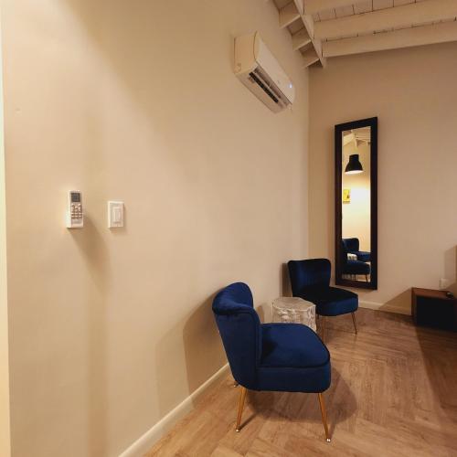 a room with two blue chairs and a mirror at Private Home Studio Central Located in Miami 2 in Opa-locka