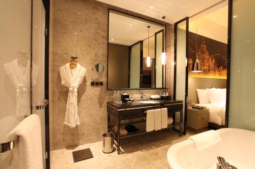a bathroom with a robe hanging in a shower at Wanda Realm Jiangmen in Jiangmen