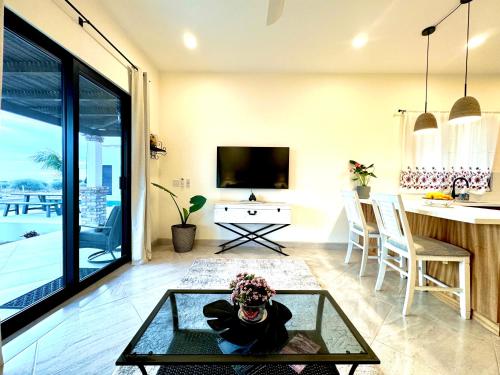 een woonkamer met een glazen salontafel en een keuken bij Brand NEW Casita Clásica in El Pescadero
