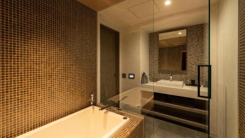 uma casa de banho com uma banheira e um lavatório em OND HOTEL（オンドホテル） em Takeo