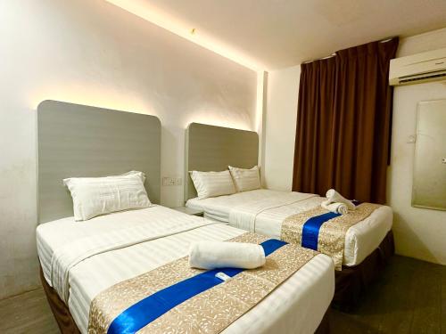 um quarto de hotel com 2 camas individuais com toques azuis em Park Hotel em Kota Kinabalu