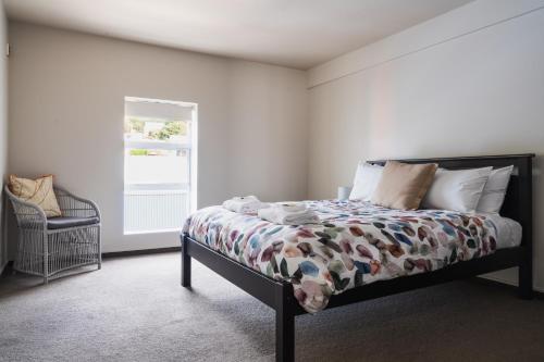 a bedroom with a bed and a window at Apartment on Manor in Dunedin