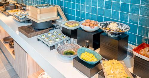 a buffet with different types of food on a counter at Grids Premium Hotel Kumamoto in Kumamoto