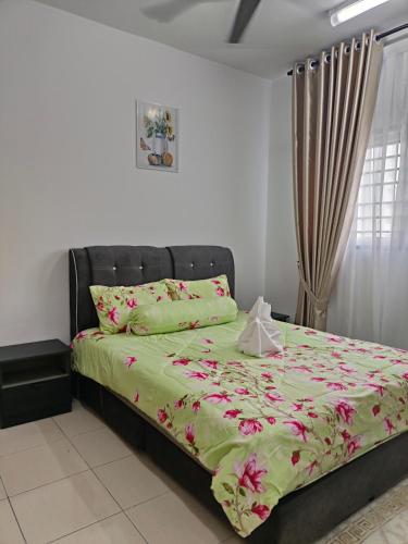 een slaapkamer met een bed met een groen dekbed bij ABA Residence Airport Way in Sepang
