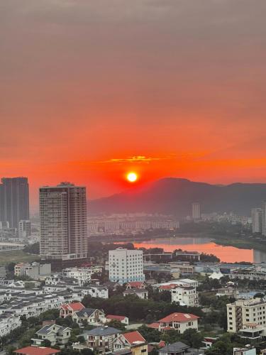 a city skyline with the sun setting in the sky at Homestay Hạ Long VIP in Ha Long