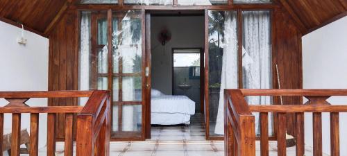 um quarto com 2 cadeiras de madeira e um quarto em Nan Bungalows Tetebatu em Tetebatu