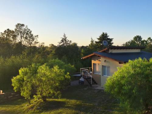 une petite maison dans un champ arboré dans l'établissement Terrazas de Nahuascat, à Santa Rosa de Calamuchita