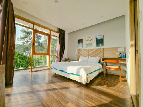- une chambre avec un lit, un bureau et une fenêtre dans l'établissement Vindy House, à Đà Lạt