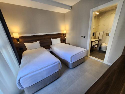 a hotel room with two beds and a bathroom at Lulubay Rooms & Suites in Kusadası