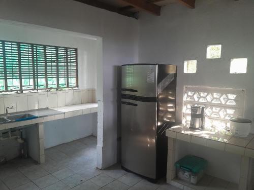 eine Küche mit einem Kühlschrank aus Edelstahl und einer Spüle in der Unterkunft Sarita's House in Esterillos Este