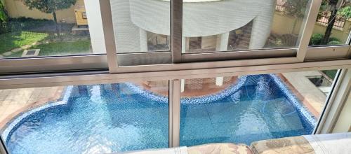 een raam met uitzicht op een zwembad bij Luzira port bell lake side apartment in Kampala