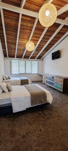 a large bedroom with two beds and a flat screen tv at Rústic Quinta La Aurora in Baños