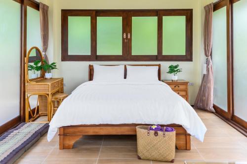 a bedroom with a large bed and two windows at Bikini Villas Koh Chang in Ko Chang