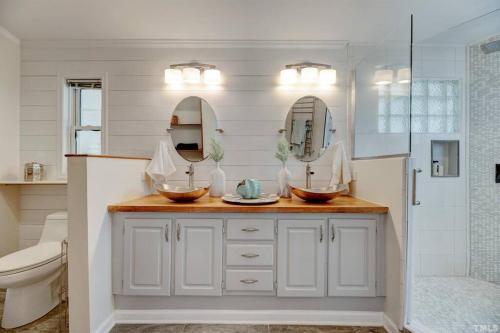 a bathroom with two sinks and a shower at Sovereign Cottage - Farm Land/Hot Tub/Outdoor Area in Fuquay-Varina