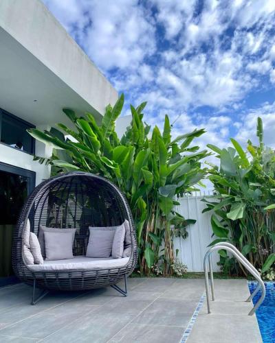 a wicker chair sitting on a patio with plants at The Vineyard at Tanauan in Tanauan
