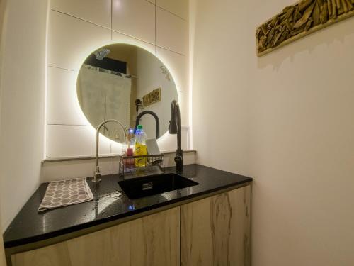 bagno con lavandino e specchio di Comfort STUDIO Arihomestay a Kuching