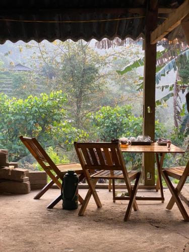 een tafel en stoelen in een kamer met uitzicht bij Bikki jungle homestay in Ha Giang