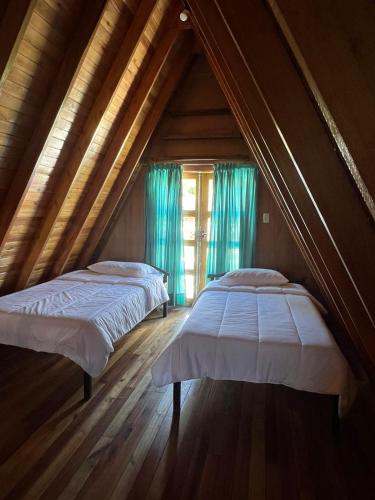 two beds in a room with wooden ceilings at El Sueño in San Bernardino