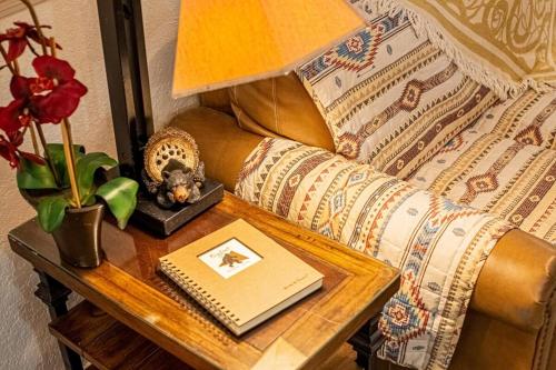 a table with a lamp and a book on a couch at Cabin C in the Gatlinburg Art & Craft Community in Gatlinburg
