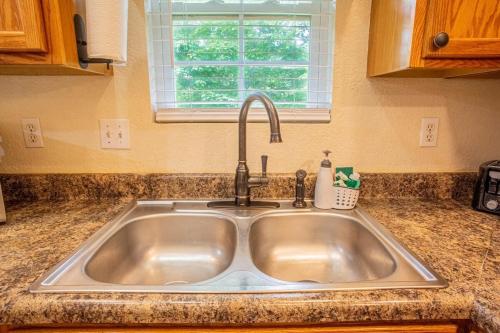 a stainless steel sink in a kitchen with a window at Cabin C in the Gatlinburg Art & Craft Community in Gatlinburg
