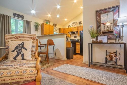 a living room with a chair and a kitchen at Cabin C in the Gatlinburg Art & Craft Community in Gatlinburg