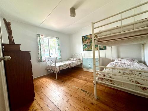 - une chambre avec 2 lits superposés et une fenêtre dans l'établissement Kioloa Beach Cabins, à Kioloa