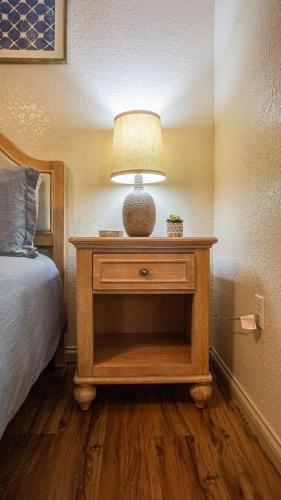 a table with a lamp on it next to a bed at Cabin C in the Gatlinburg Art & Craft Community in Gatlinburg