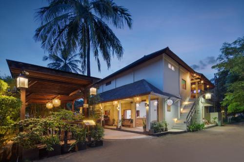 een resort met een gebouw met een palmboom op de achtergrond bij Utara Villas in Gili Trawangan