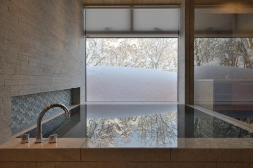 a bathroom with a sink and a window with a mirror at ZEN - Vacation STAY 74302v in Niseko