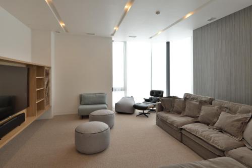 a living room with a couch and a tv and chairs at ZEN - Vacation STAY 74302v in Niseko